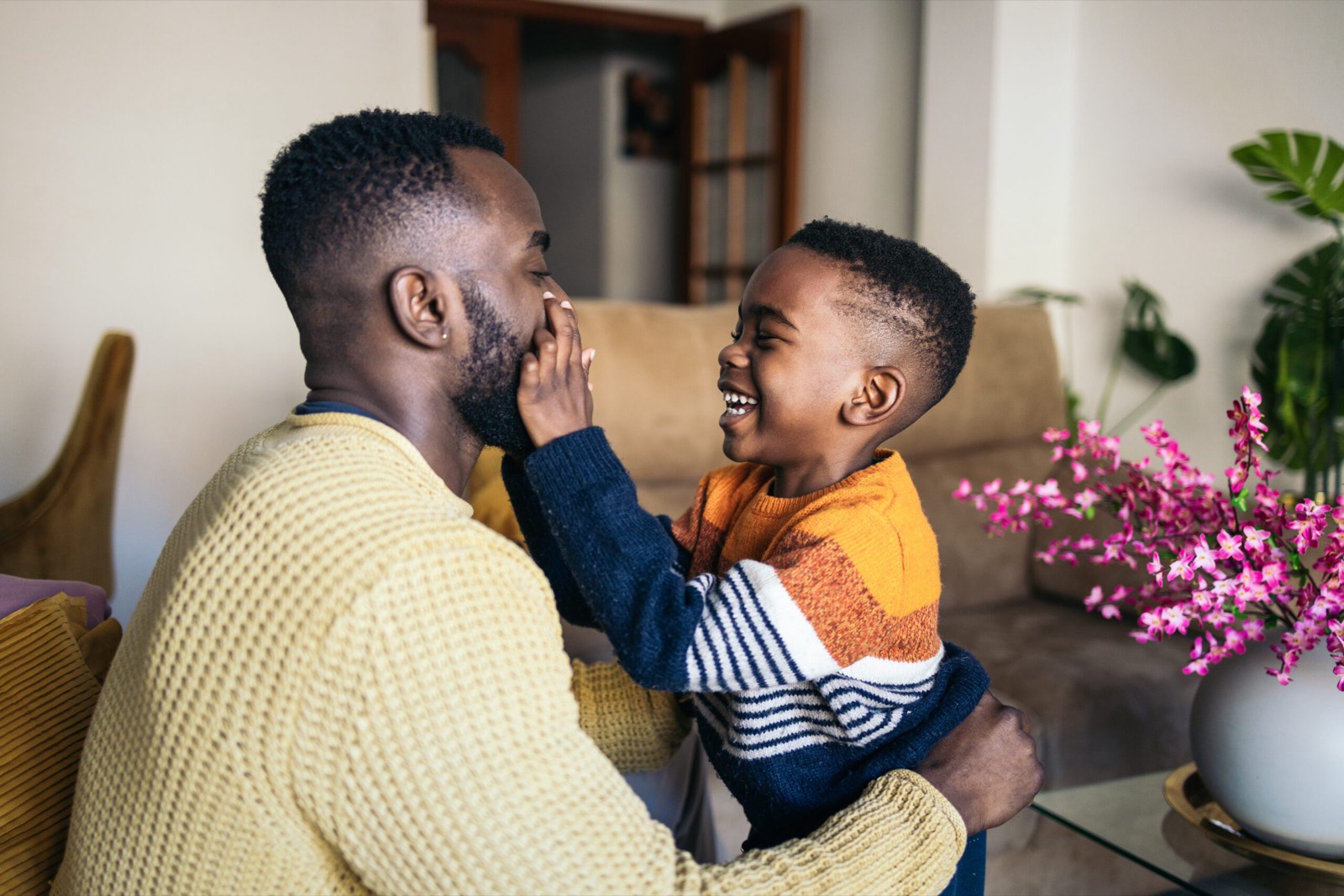 A foster carer and a child laughing together at home